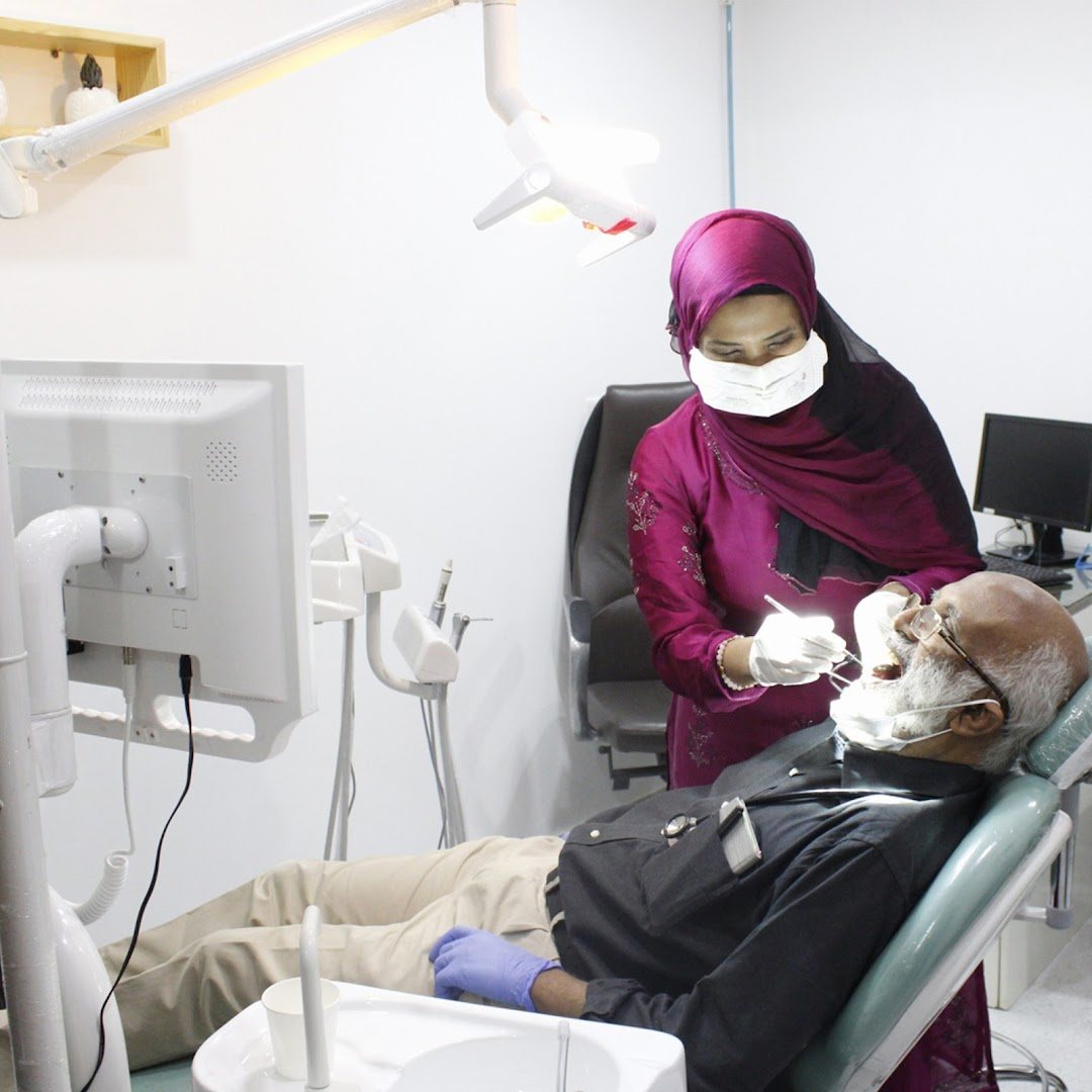 A specialist at LA Dent Studio treating a patient in the wine-toned treatment room